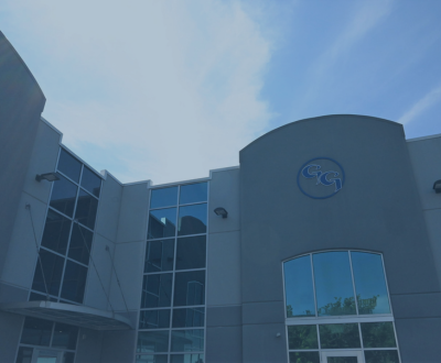 Photo of Glenny Glass headquarters with a blue overlay – tempered, laminated, and specialty glass solutions.